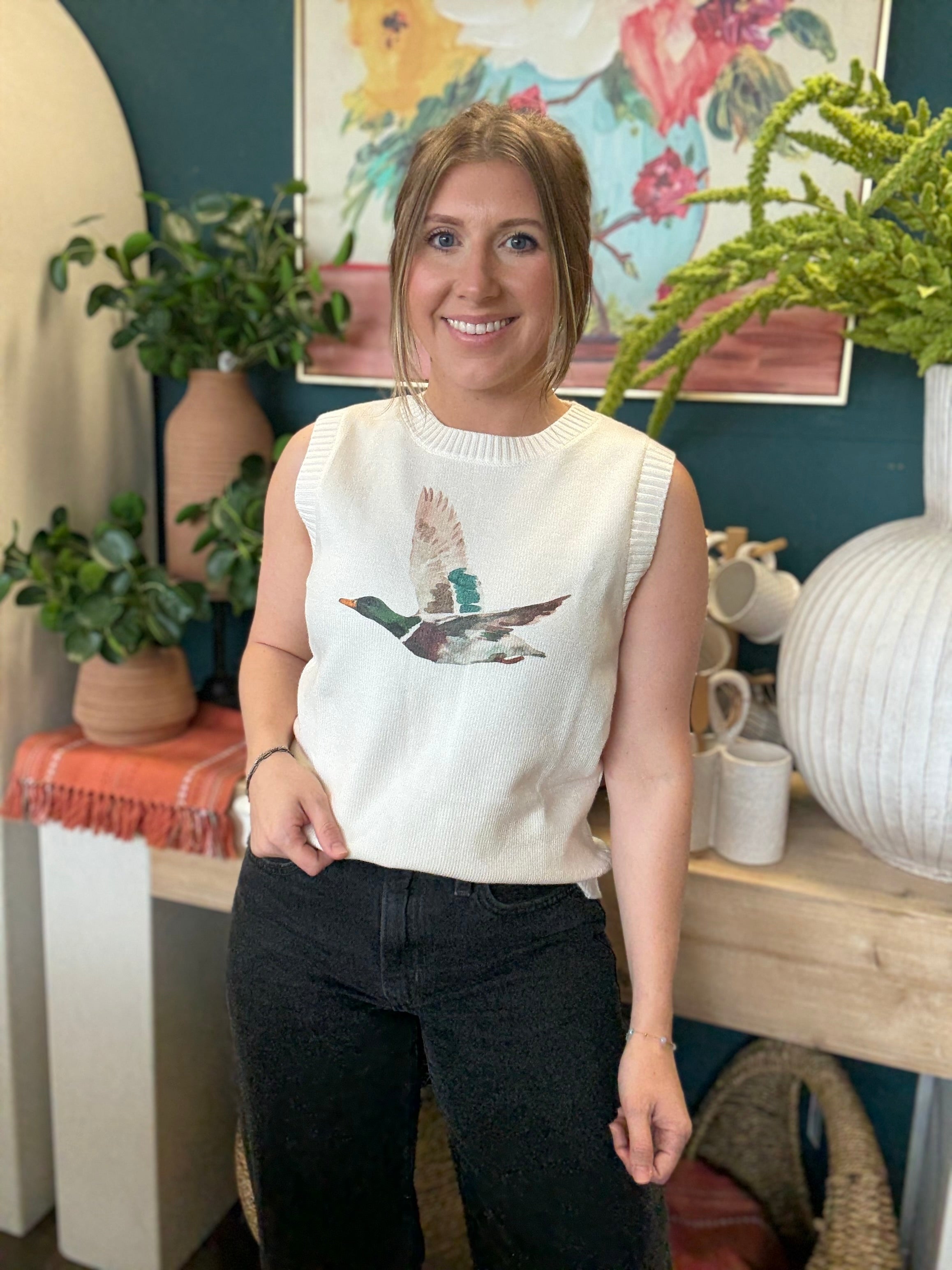 woman wearing ivory sweater vest with flying mallard duck graphic