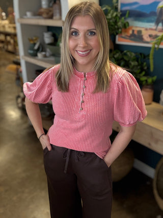 woman wearing coral waffle knit boutique top with puff sleeves and button neckline