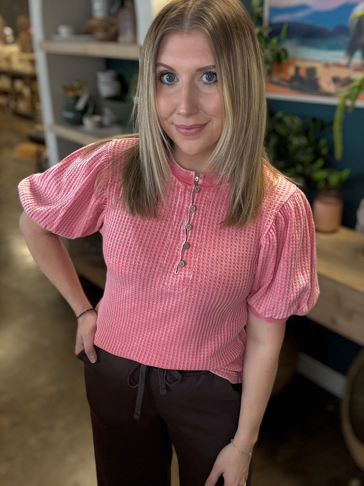 woman wearing coral waffle knit boutique top with puff sleeves and button neckline
