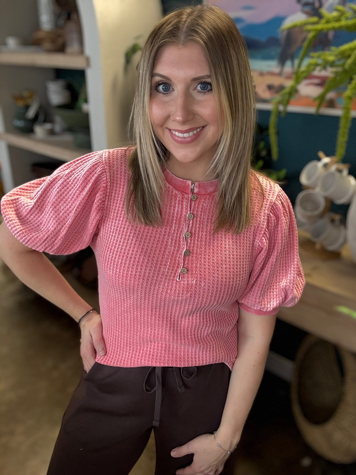 woman wearing coral waffle knit boutique top with puff sleeves and button neckline