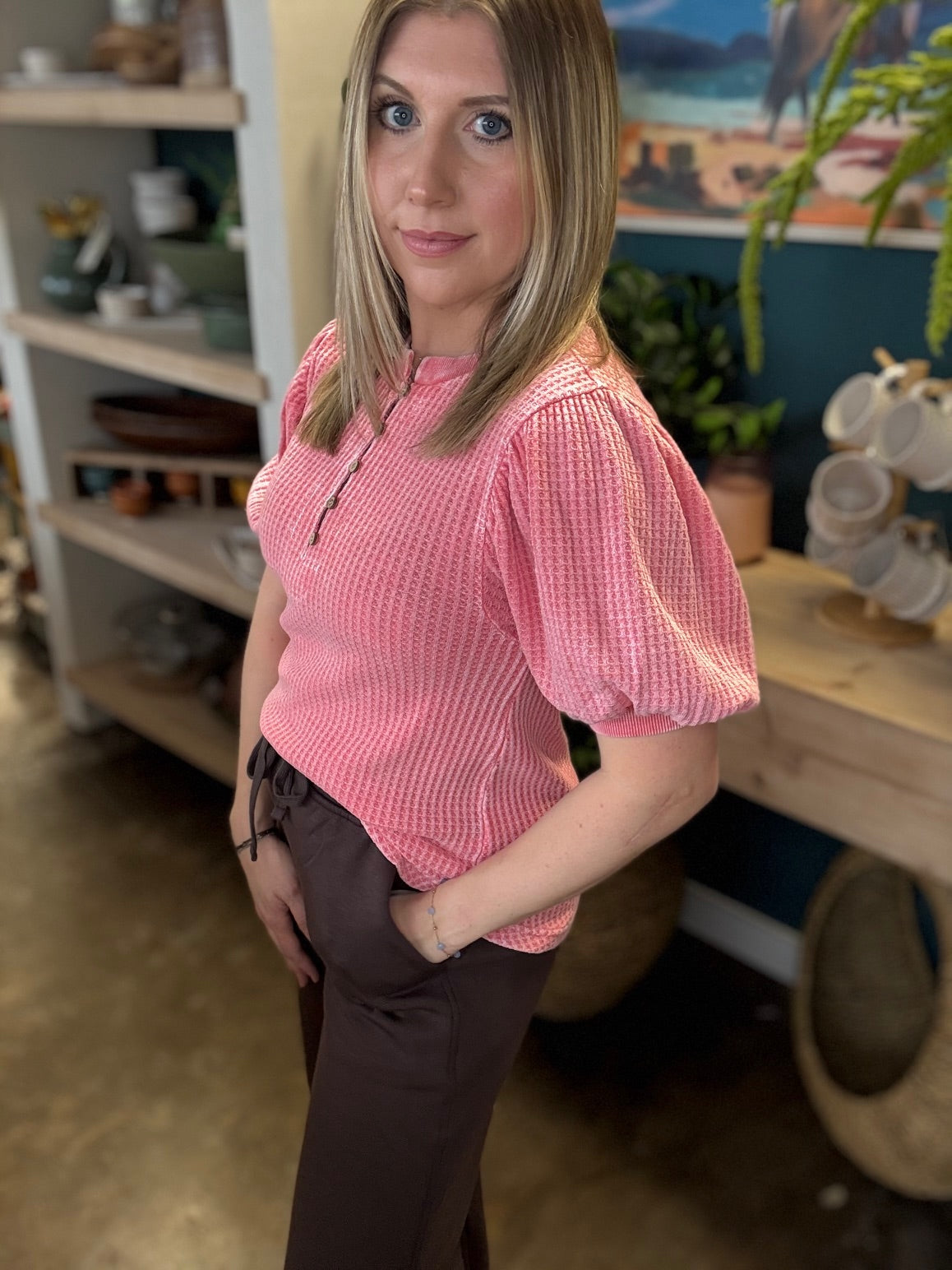 woman wearing coral waffle knit boutique top with puff sleeves and button neckline