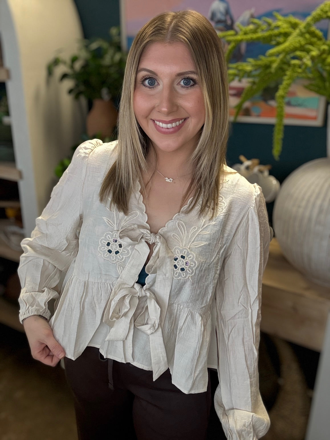 Cream embroidered tie front boutique top with floral detail styled with casual pants at Pill Box Boutique