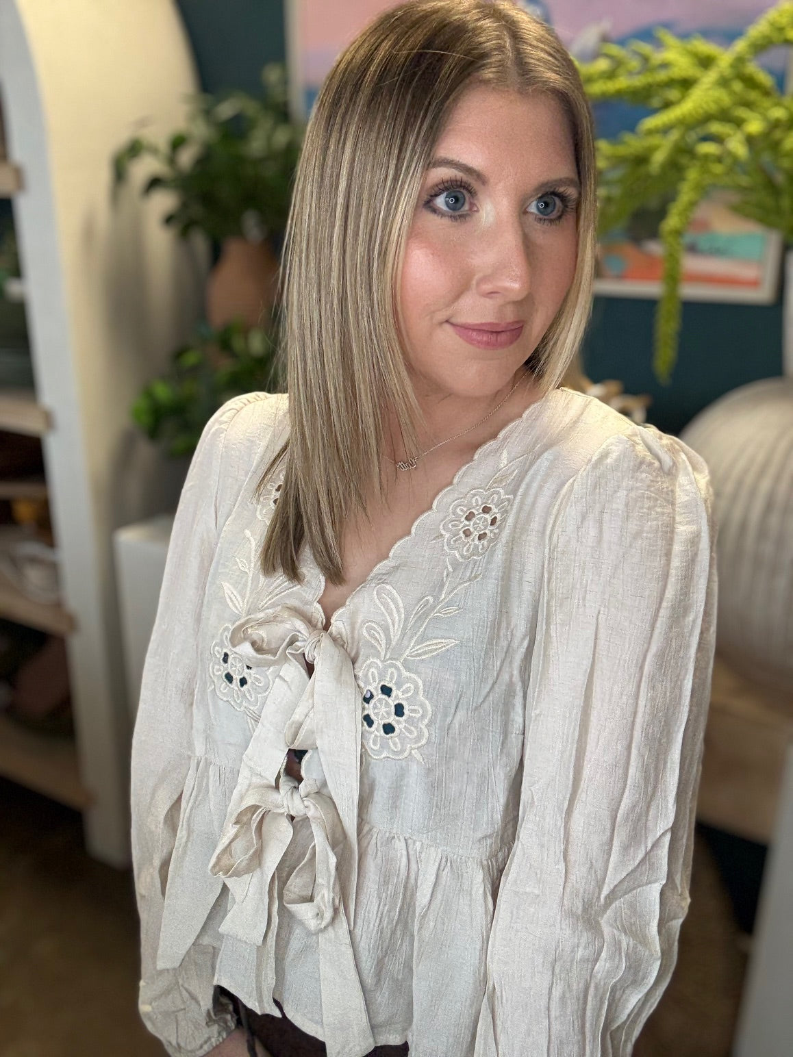 Cream embroidered tie front boutique top with floral detail styled with casual pants at Pill Box Boutique