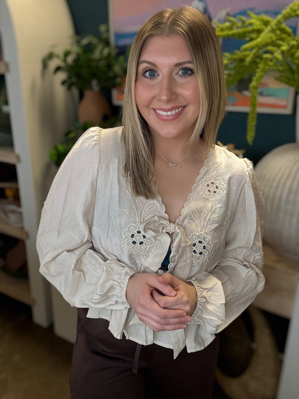Cream embroidered tie front boutique top with floral detail styled with casual pants at Pill Box Boutique
