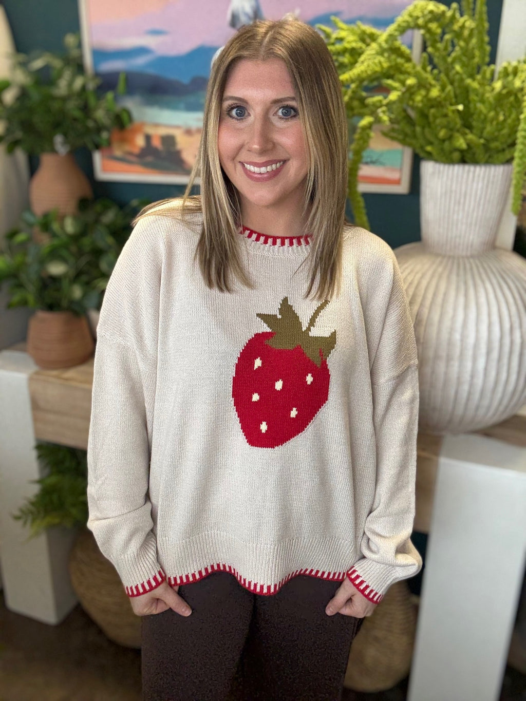 Strawberry graphic knit boutique sweater with contrast stitching styled with casual pants at Pill Box Boutique