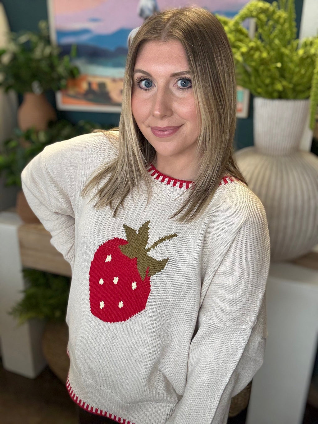 Strawberry graphic knit boutique sweater with contrast stitching styled with casual pants at Pill Box Boutique