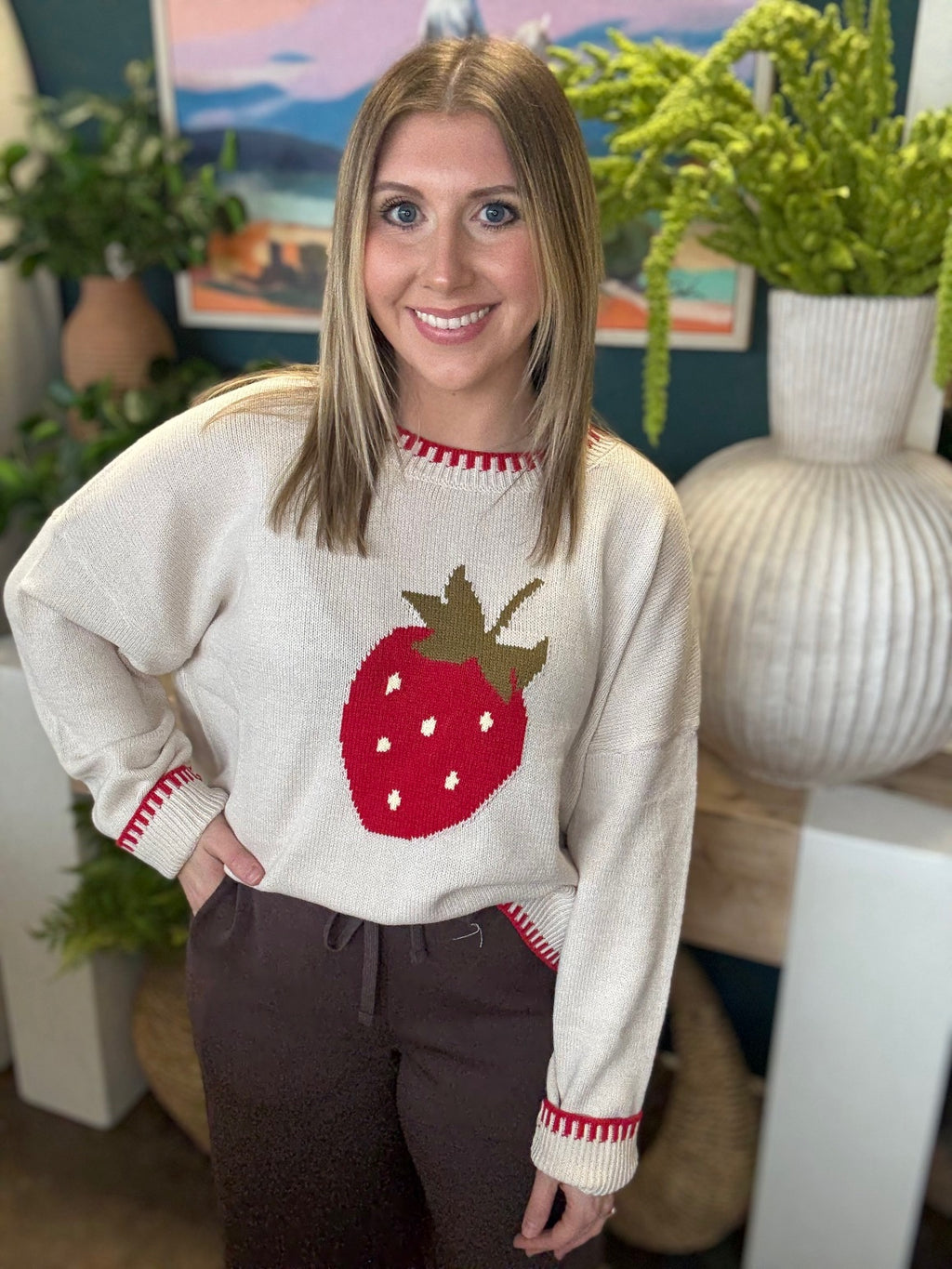 Strawberry graphic knit boutique sweater with contrast stitching styled with casual pants at Pill Box Boutique