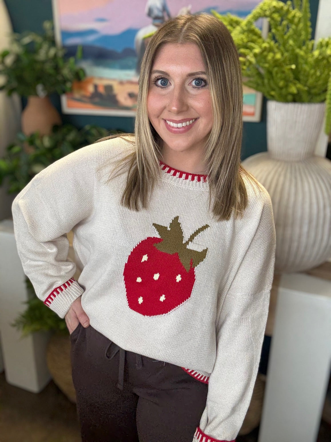 Strawberry graphic knit boutique sweater with contrast stitching styled with casual pants at Pill Box Boutique