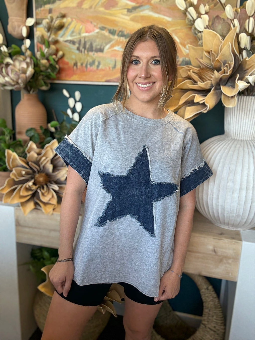 women's oversized gray top with distressed denim star applique and rolled denim sleeves