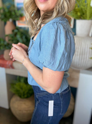 woman wearing embroidered chambray boutique top with puff sleeves and button front