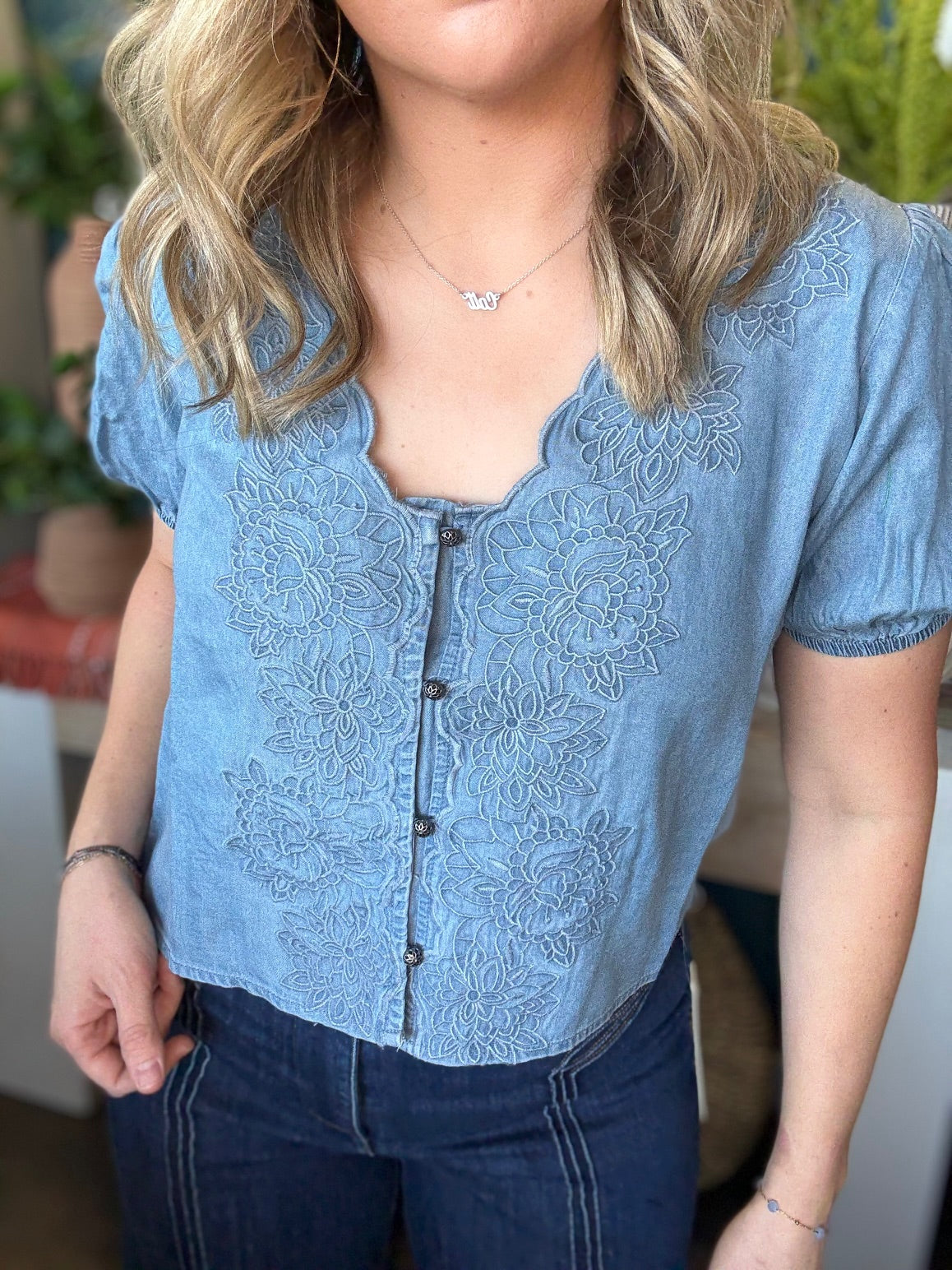 woman wearing embroidered chambray boutique top with puff sleeves and button front