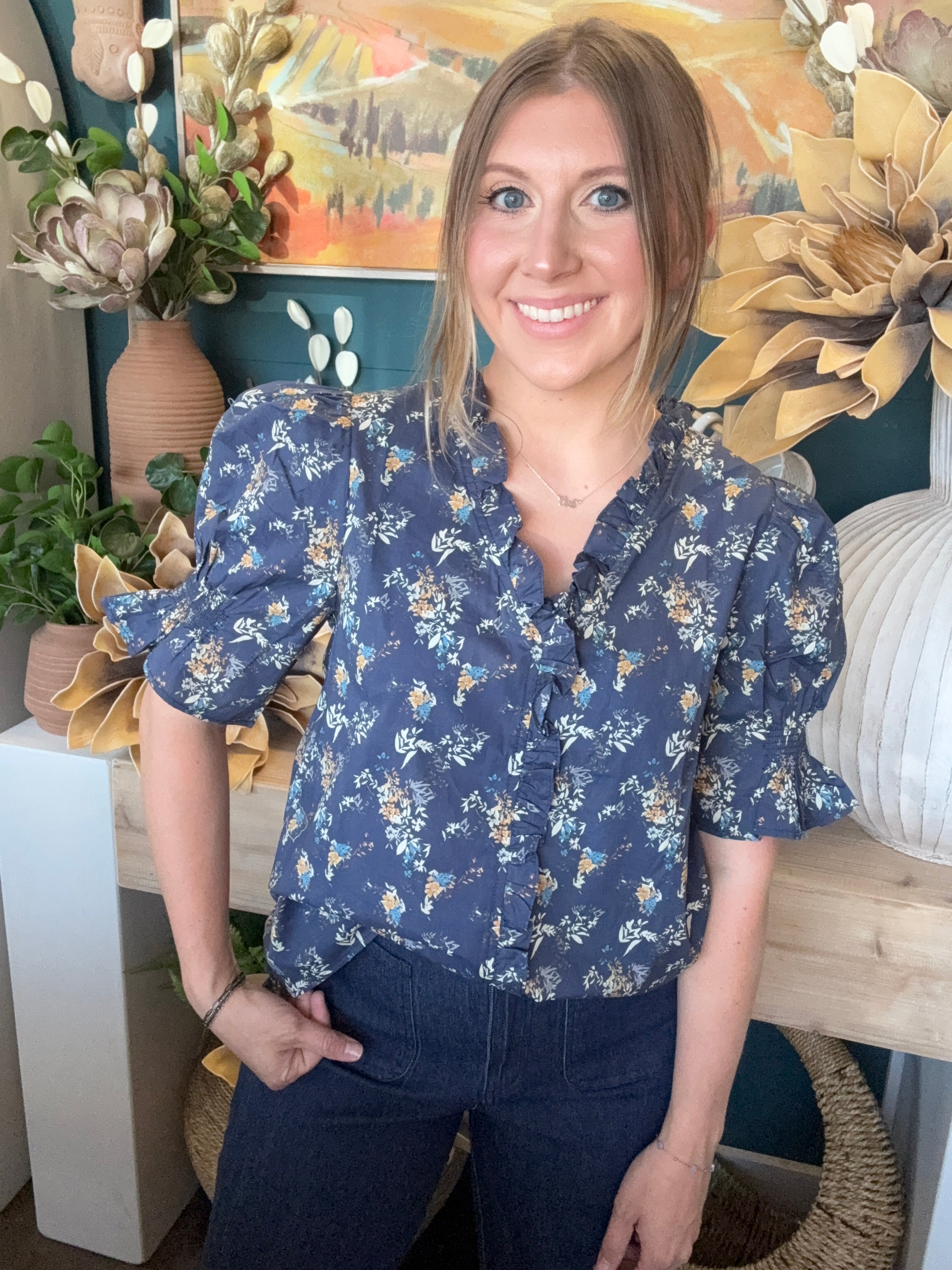 navy floral blouse with ruffled neckline and short flutter sleeves