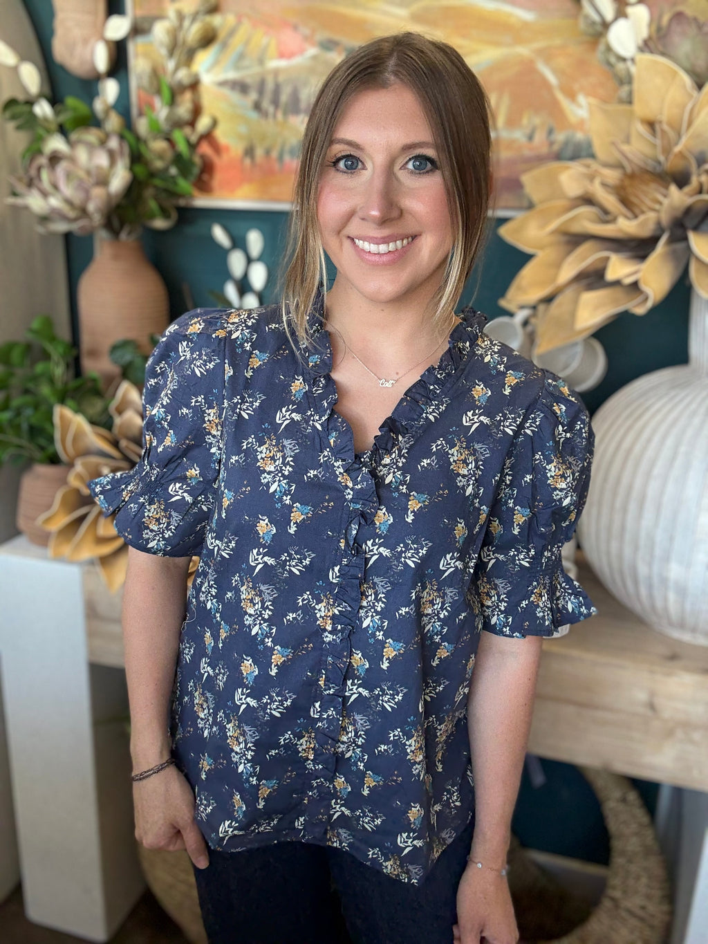 navy floral blouse with ruffled neckline and short flutter sleeves
