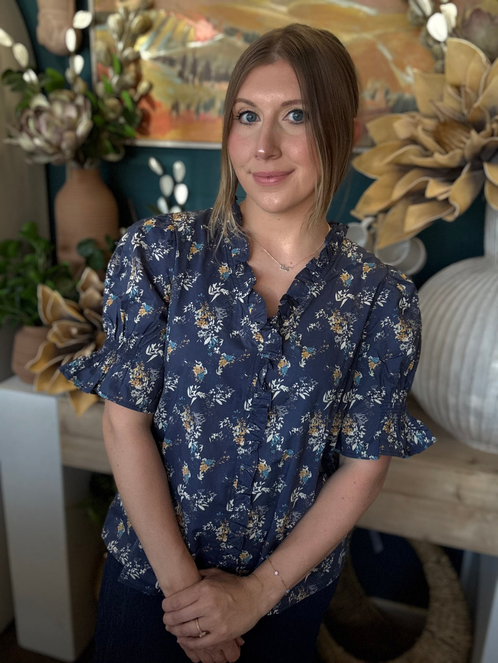navy floral blouse with ruffled neckline and short flutter sleeves
