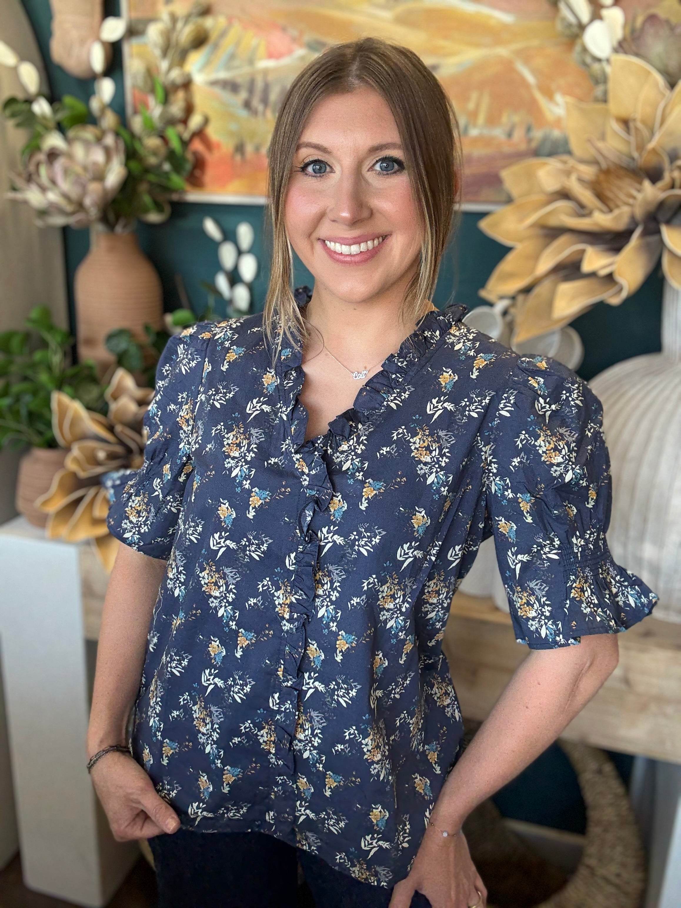 navy floral blouse with ruffled neckline and short flutter sleeves