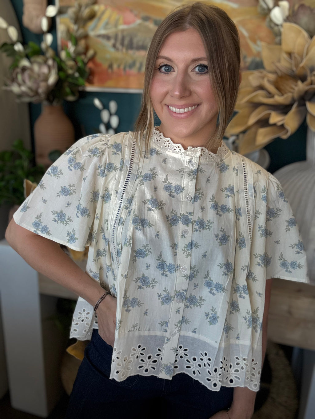 ivory floral blouse with blue flowers lace trim flutter sleeves and eyelet hem detail