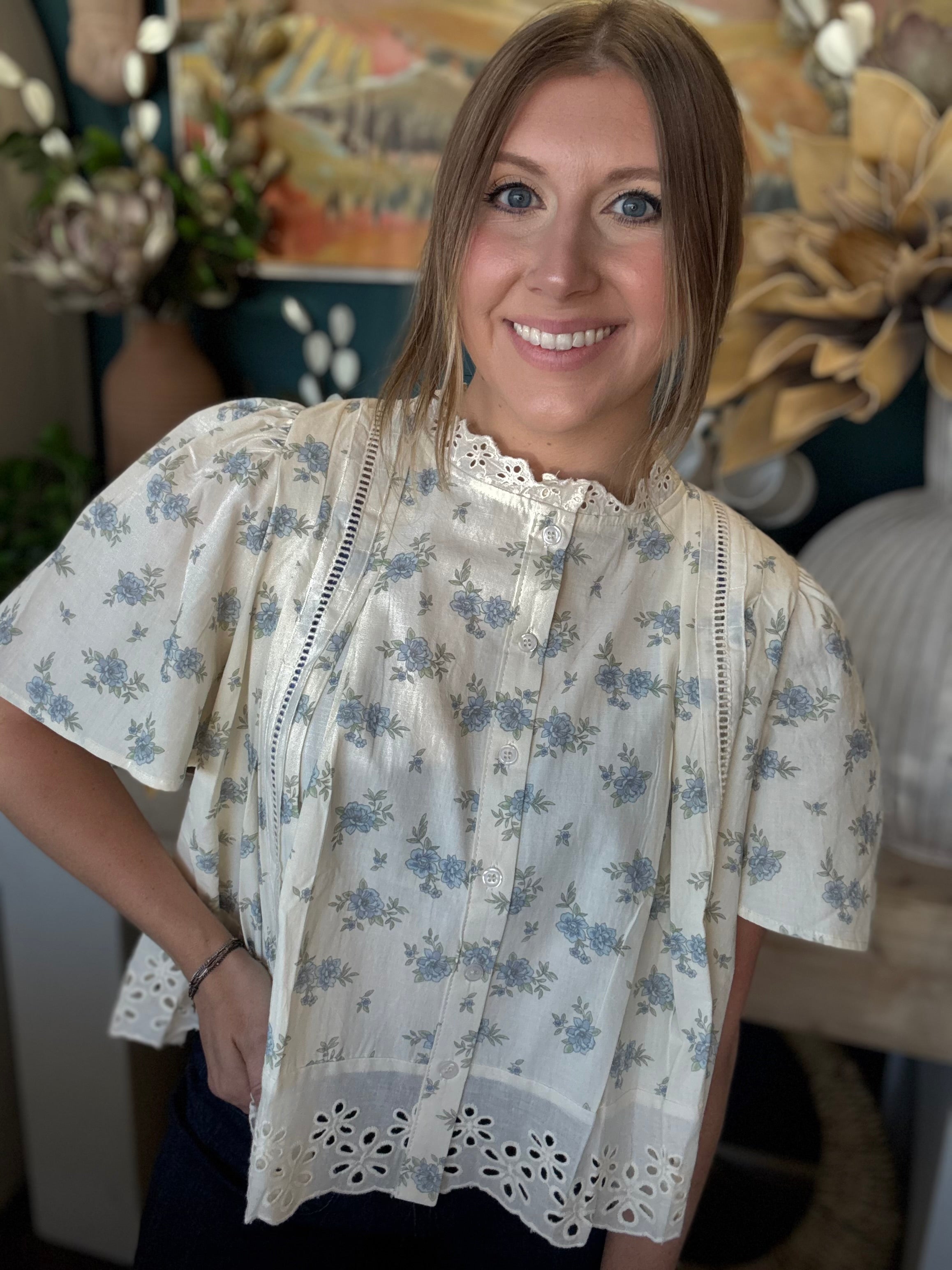 ivory floral blouse with blue flowers lace trim flutter sleeves and eyelet hem detail