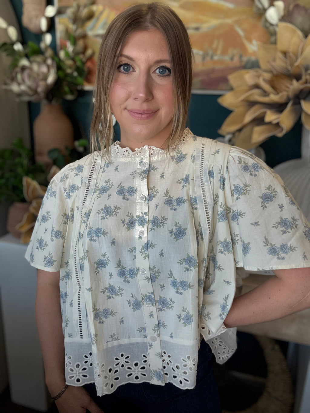 ivory floral blouse with blue flowers lace trim flutter sleeves and eyelet hem detail