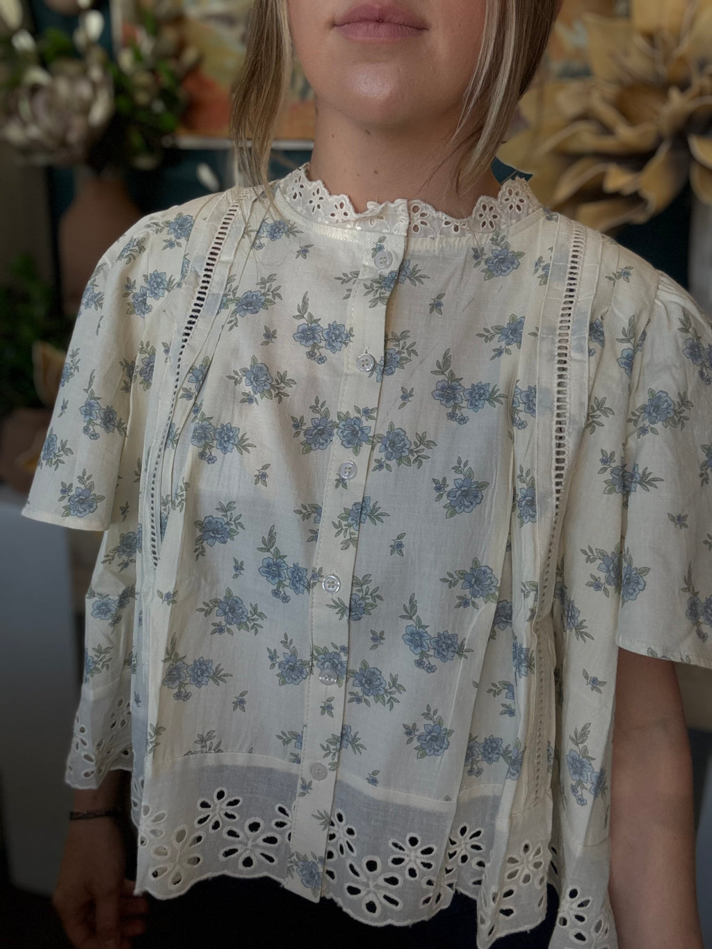 ivory floral blouse with blue flowers lace trim flutter sleeves and eyelet hem detail