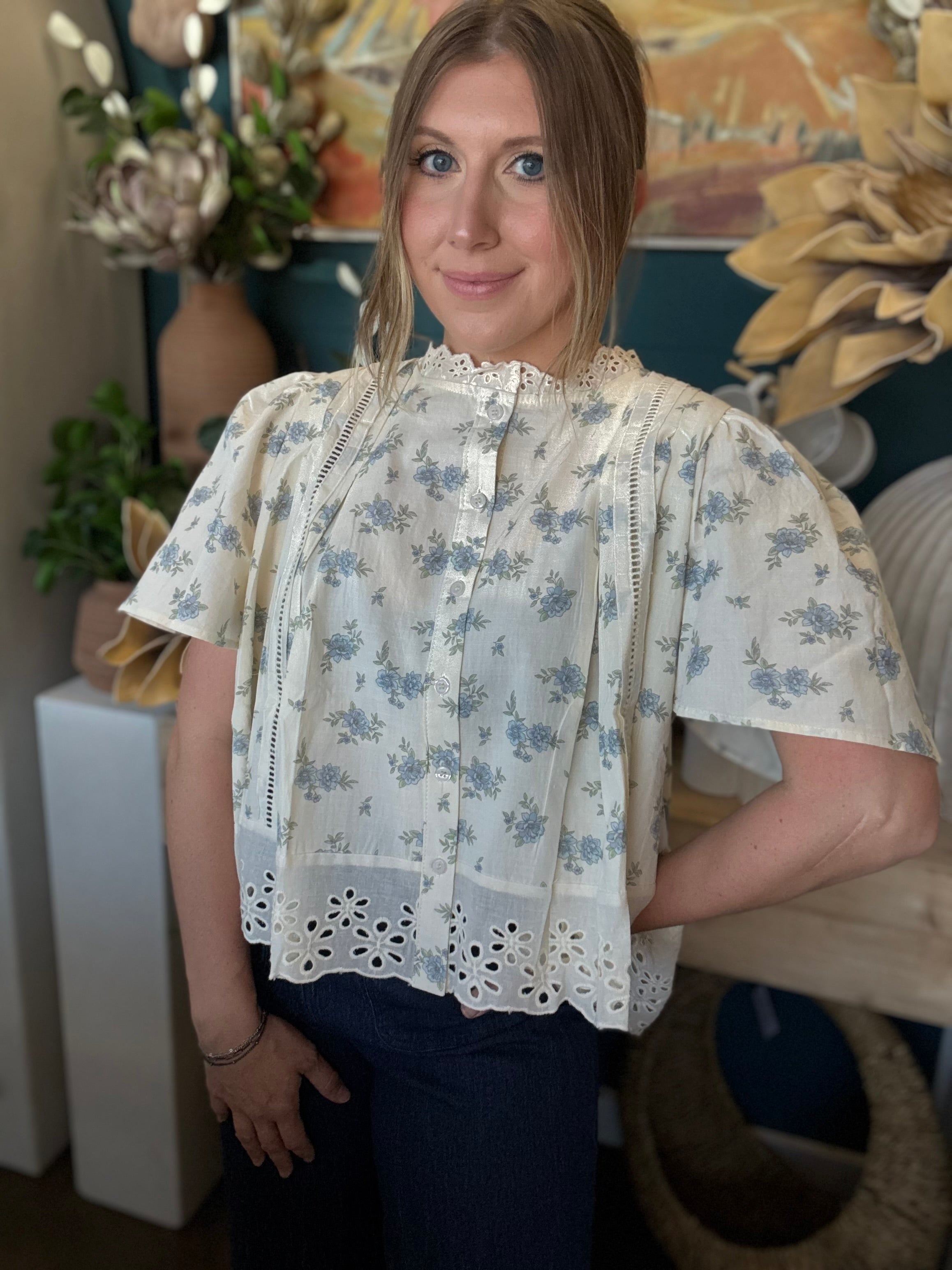 ivory floral blouse with blue flowers lace trim flutter sleeves and eyelet hem detail