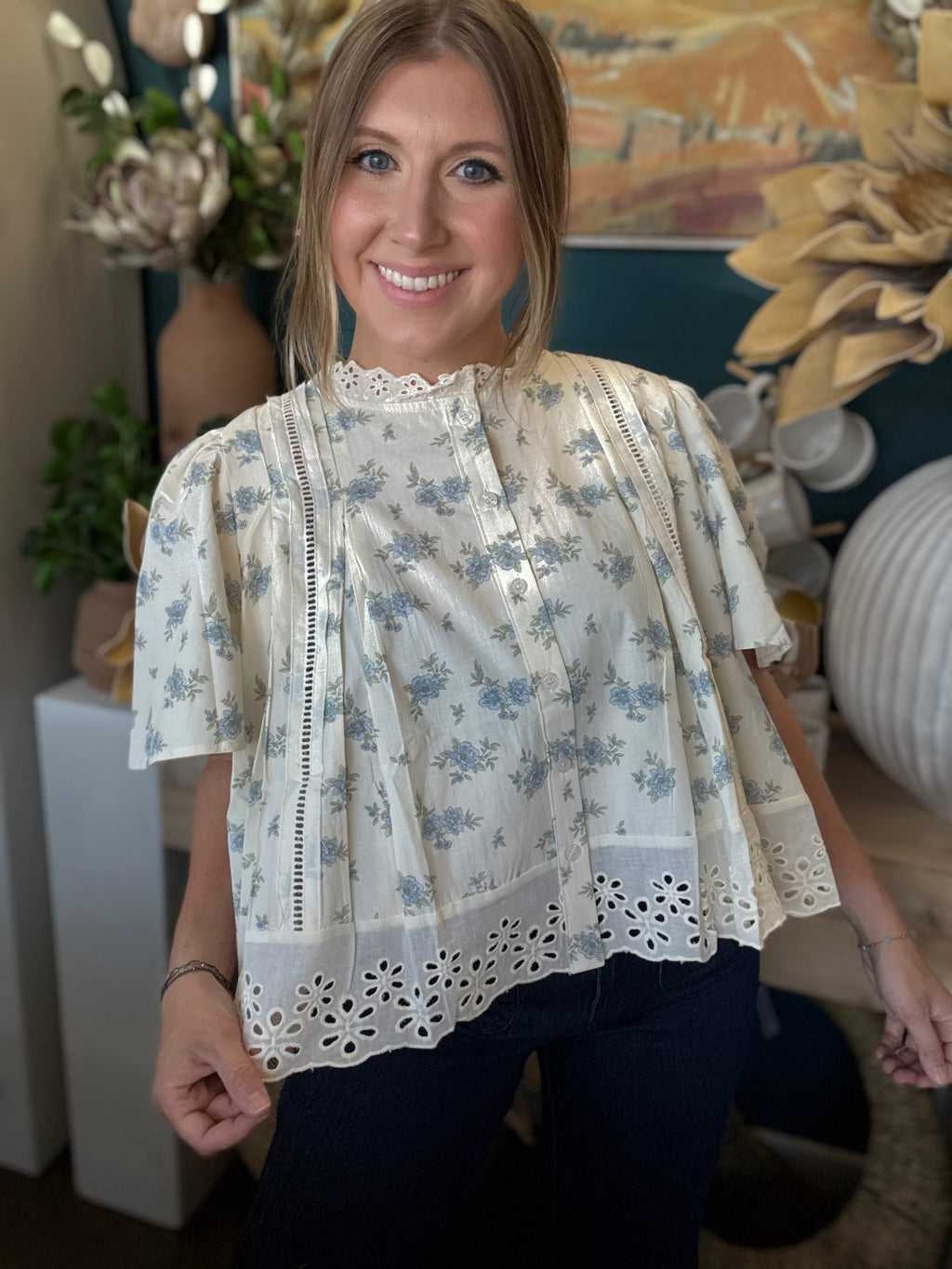 ivory floral blouse with blue flowers lace trim flutter sleeves and eyelet hem detail