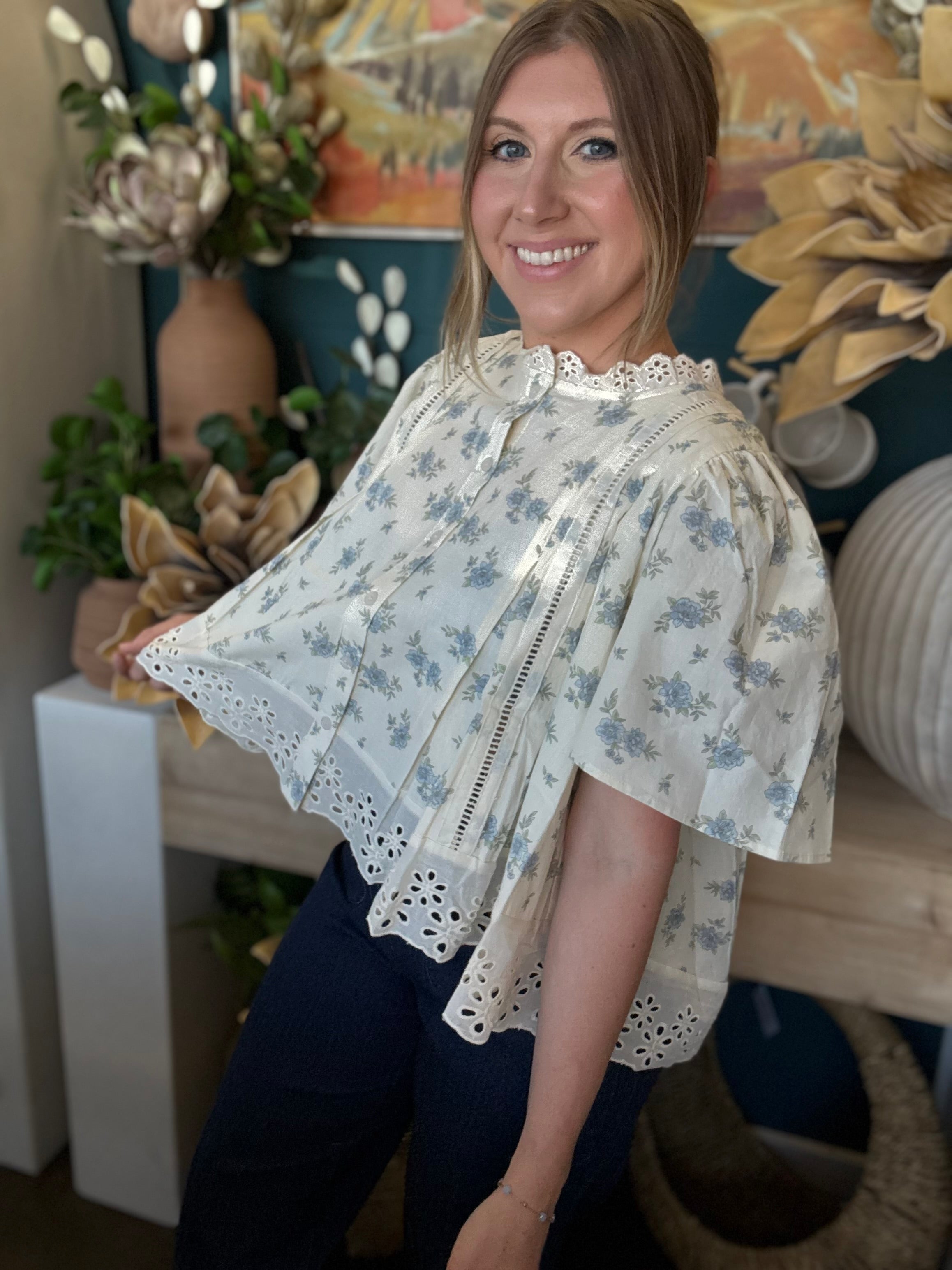 ivory floral blouse with blue flowers lace trim flutter sleeves and eyelet hem detail