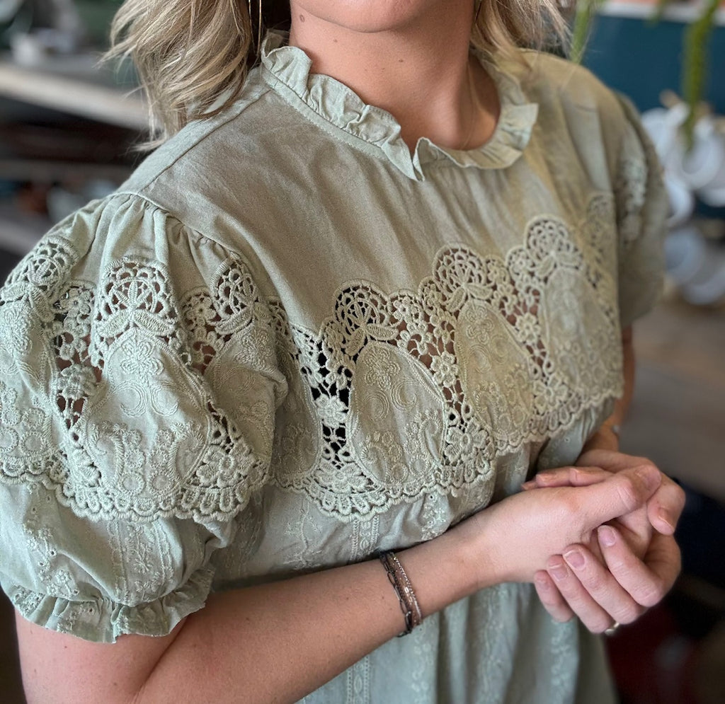 woman wearing sage green lace puff sleeve boutique blouse with embroidered fabric

Tags