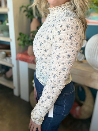 woman wearing floral smocked mock neck boutique top with long sleeves
