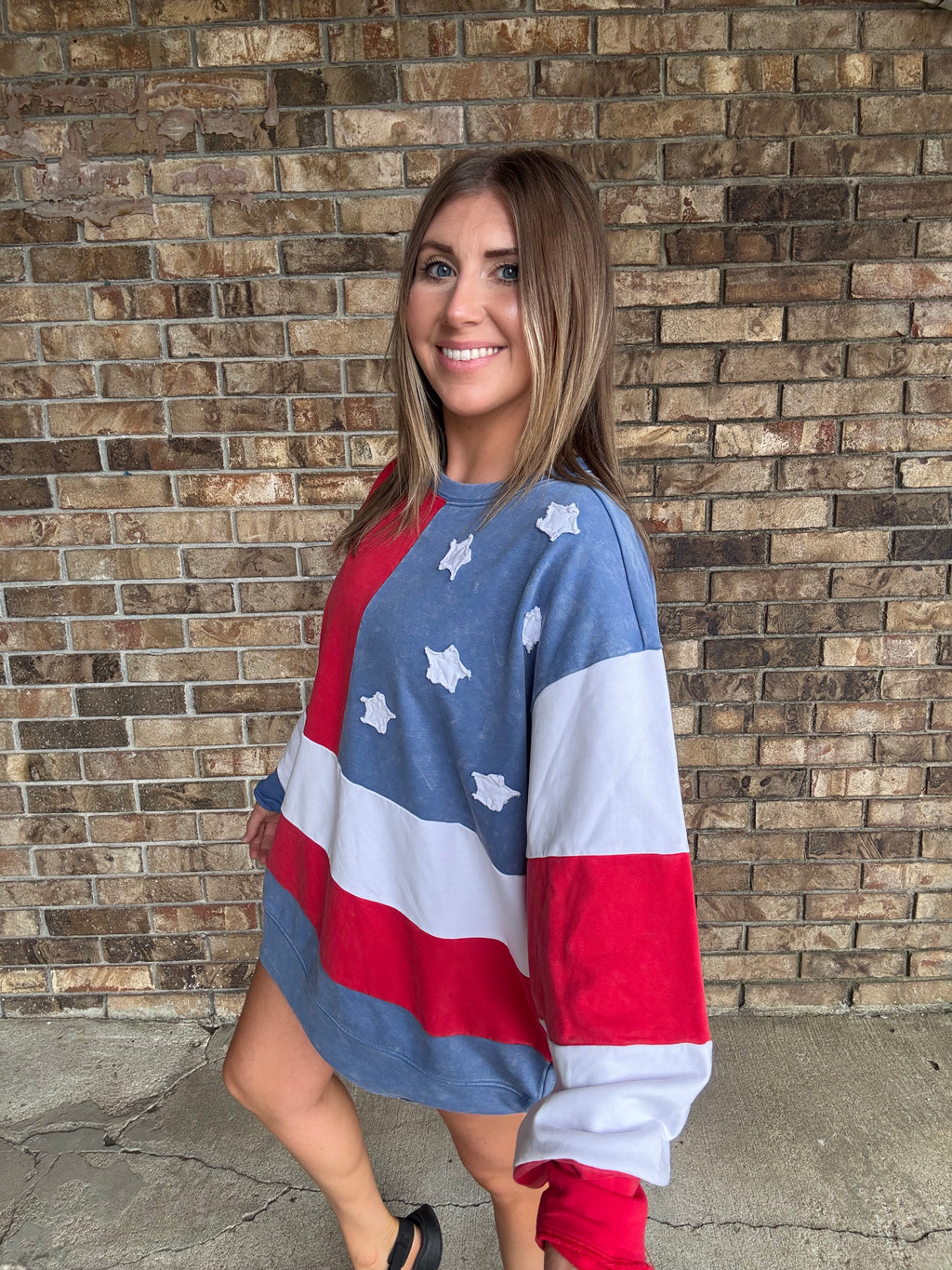 Woman wearing a mineral washed oversized Americana flag sweatshirt with vintage stars and stripes design