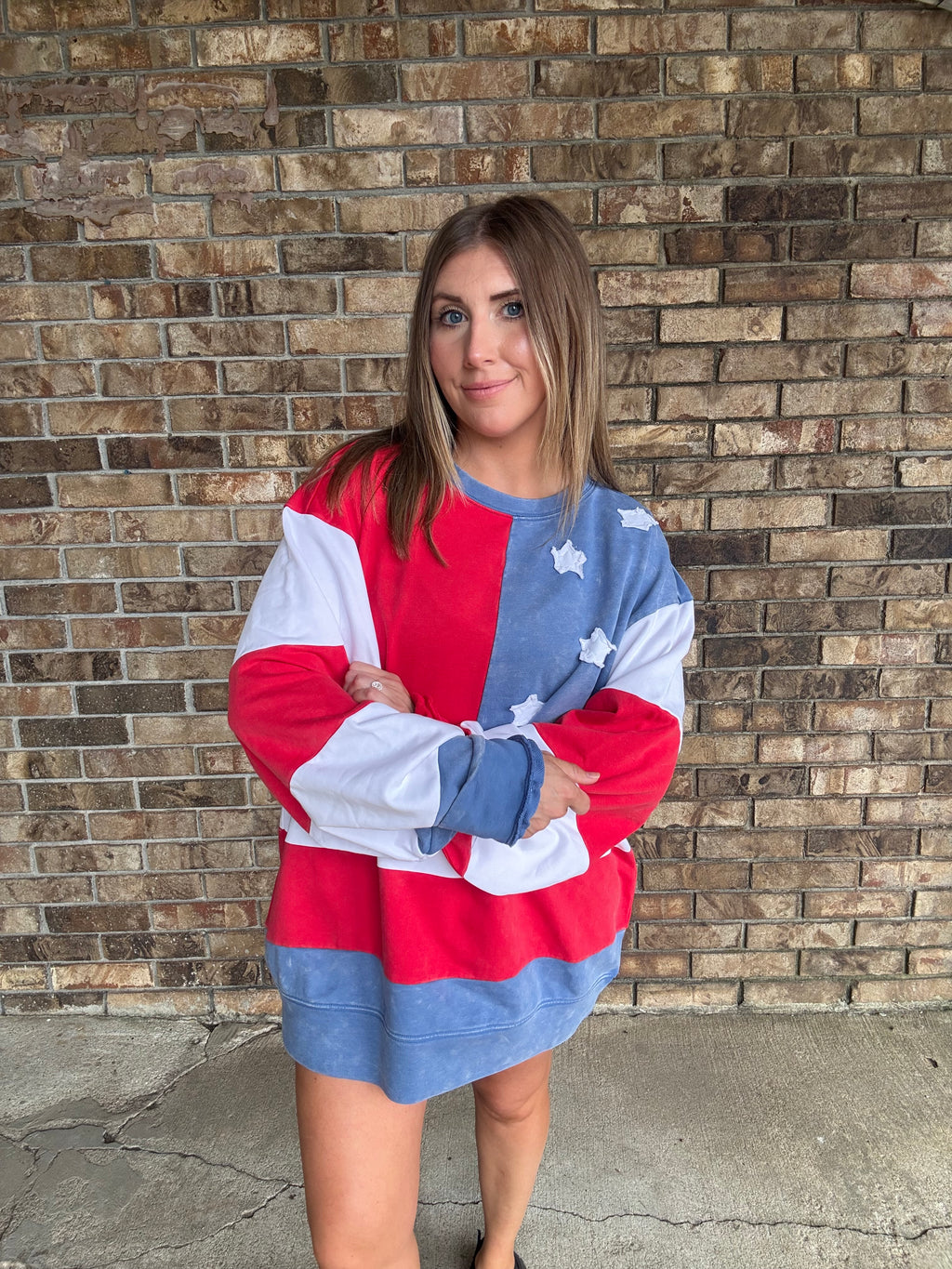 Woman wearing a mineral washed oversized Americana flag sweatshirt with vintage stars and stripes design
