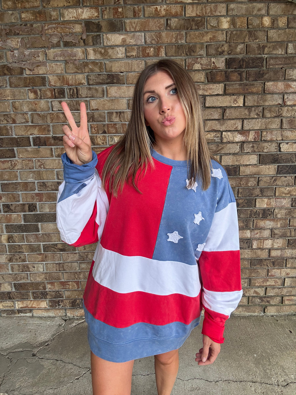 Woman wearing a mineral washed oversized Americana flag sweatshirt with vintage stars and stripes design