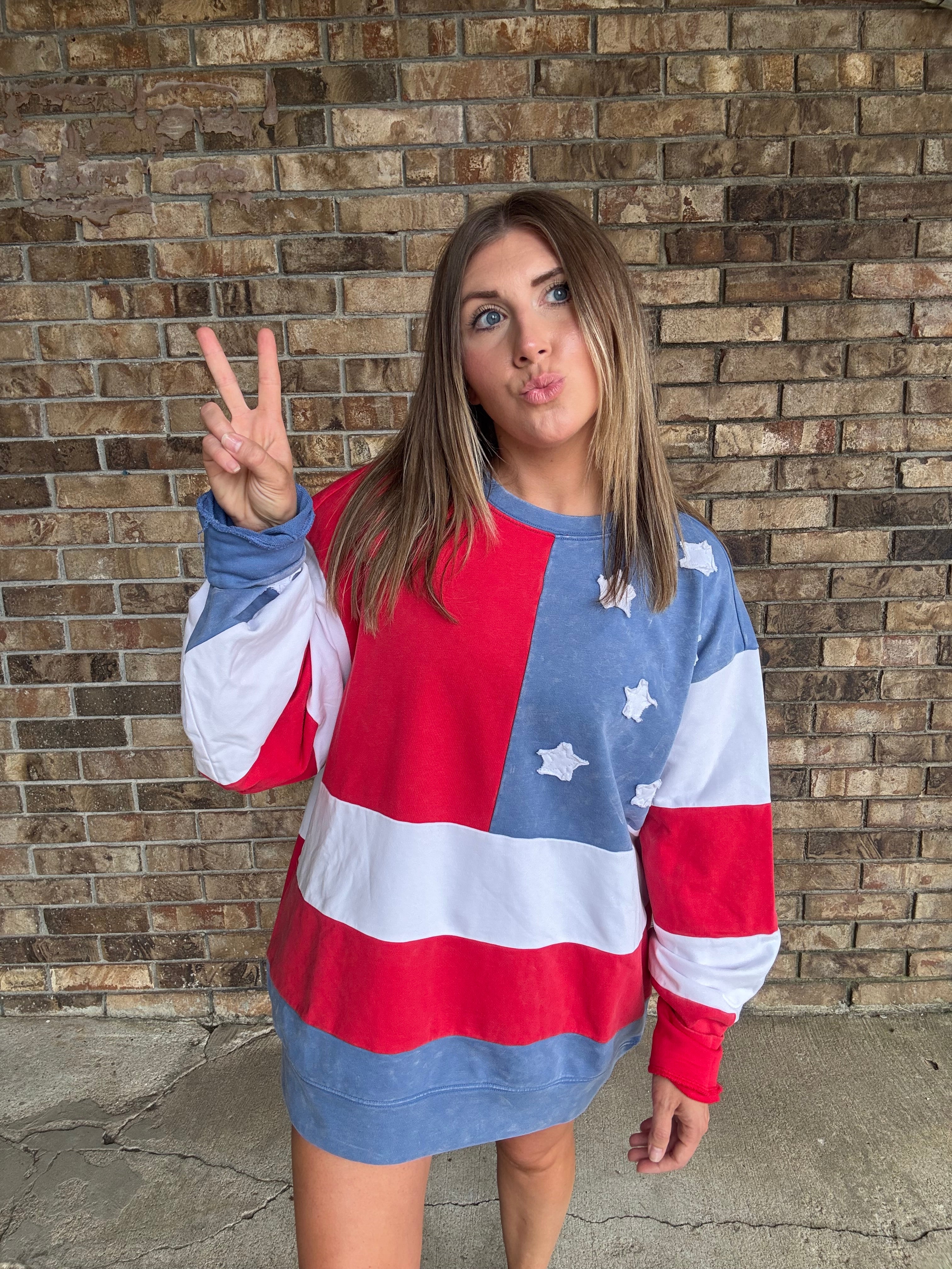 Woman wearing a mineral washed oversized Americana flag sweatshirt with vintage stars and stripes design
