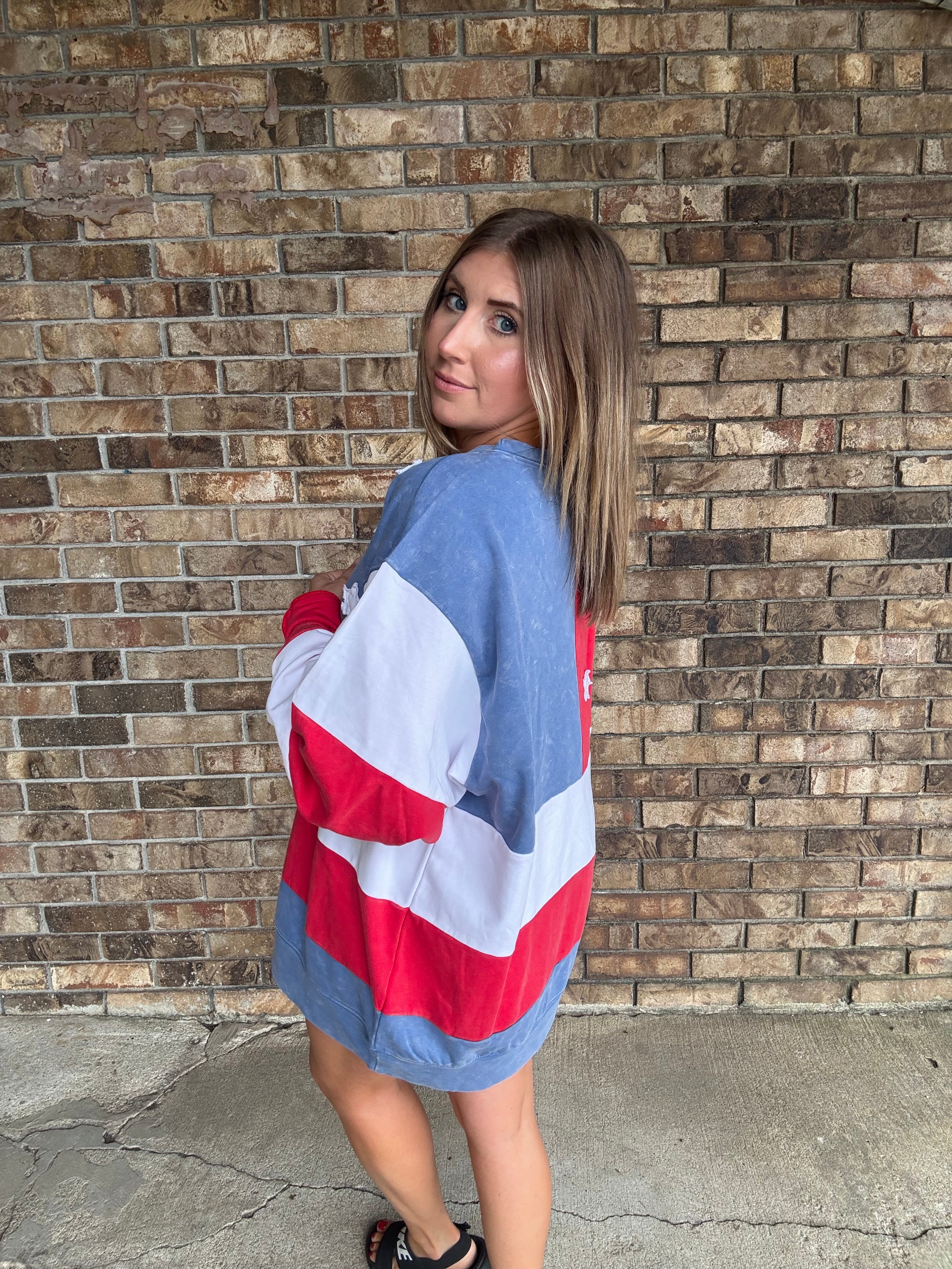 Woman wearing a mineral washed oversized Americana flag sweatshirt with vintage stars and stripes design
