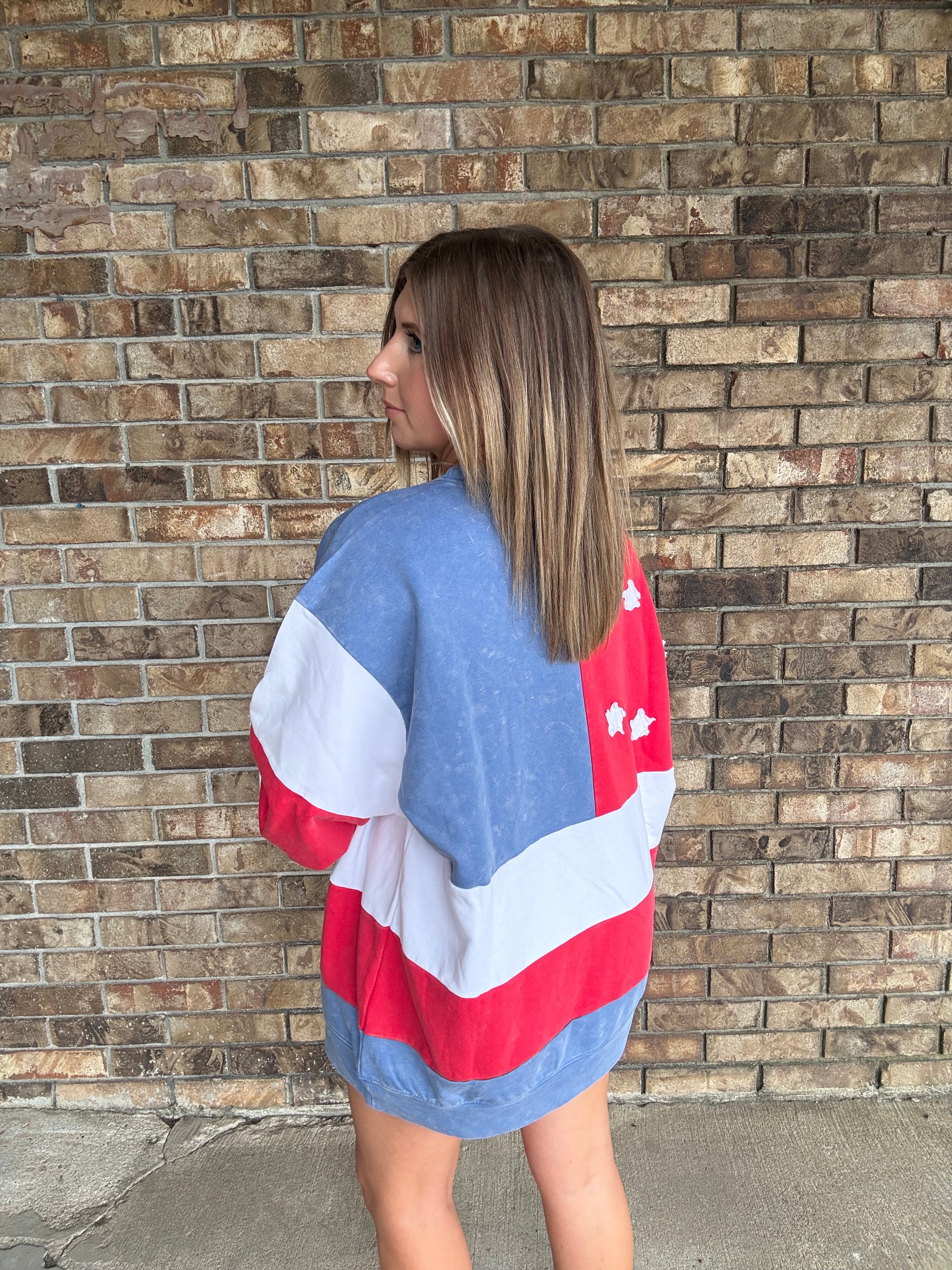 Woman wearing a mineral washed oversized Americana flag sweatshirt with vintage stars and stripes design