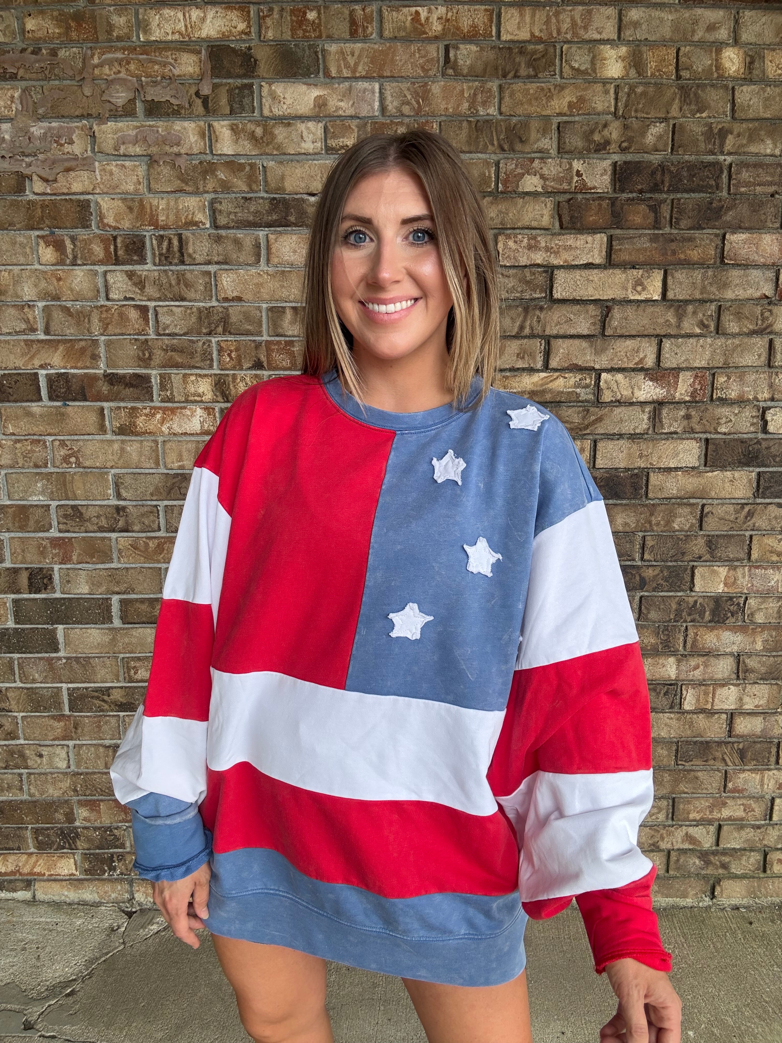 Woman wearing a mineral washed oversized Americana flag sweatshirt with vintage stars and stripes design