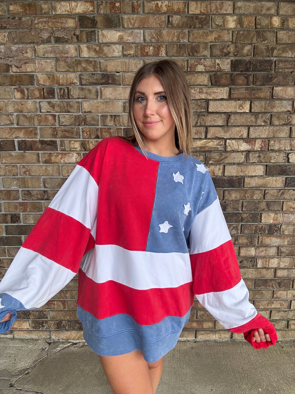 Woman wearing a mineral washed oversized Americana flag sweatshirt with vintage stars and stripes design