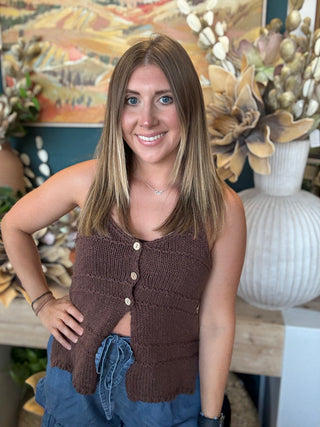 Woman wearing a mocha brown knit sweater tank top with front button details and adjustable spaghetti straps