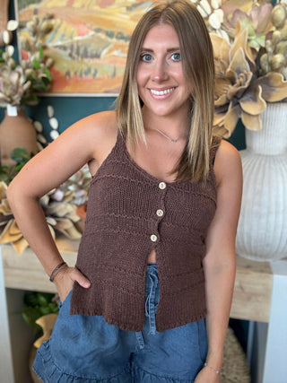 Woman wearing a mocha brown knit sweater tank top with front button details and adjustable spaghetti straps