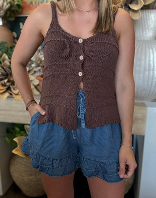 Woman wearing chambray blue ruffle hem shorts with an elastic drawstring waistband and side pockets