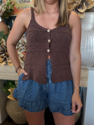 Woman wearing a mocha brown knit sweater tank top with front button details and adjustable spaghetti straps