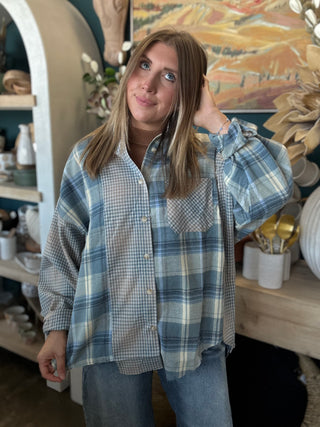 Woman wearing an oversized blue mixed plaid patchwork button-down shirt with long sleeves