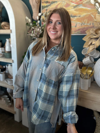 Woman wearing an oversized blue mixed plaid patchwork button-down shirt with long sleeves