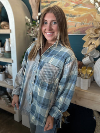 Woman wearing an oversized blue mixed plaid patchwork button-down shirt with long sleeves
