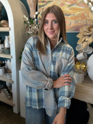 Woman wearing an oversized blue mixed plaid patchwork button-down shirt with long sleeves
