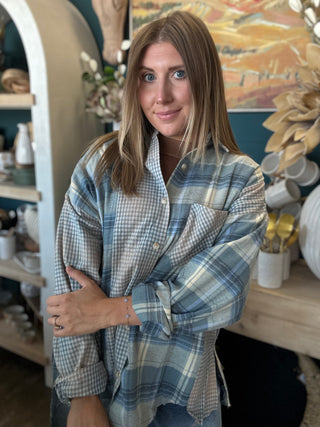 Woman wearing an oversized blue mixed plaid patchwork button-down shirt with long sleeves