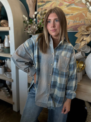Woman wearing an oversized blue mixed plaid patchwork button-down shirt with long sleeves