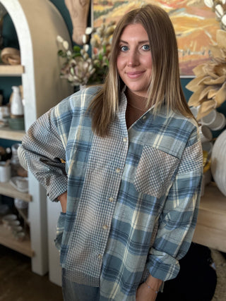 Woman wearing an oversized blue mixed plaid patchwork button-down shirt with long sleeves