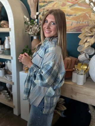Woman wearing an oversized blue mixed plaid patchwork button-down shirt with long sleeves