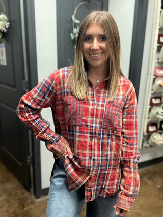 Woman wearing a vintage washed red plaid button-down shirt with chest pockets and a raw fringe hem