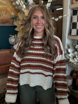 Woman wearing the Sunset Drive relaxed fit open-knit sweater in rust, camel and ivory.